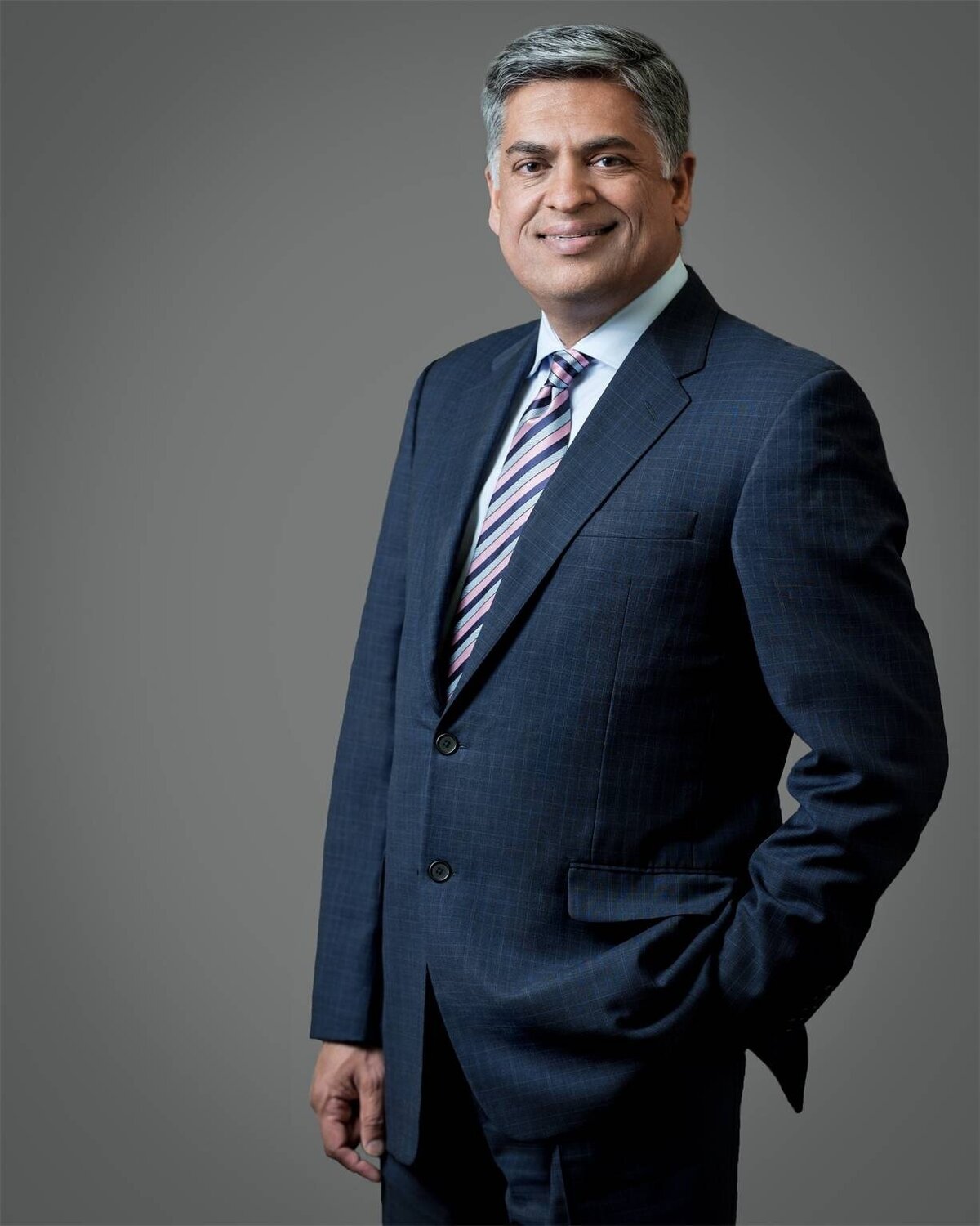 Corporate headshot of NYC business leader smiling in modern office setting