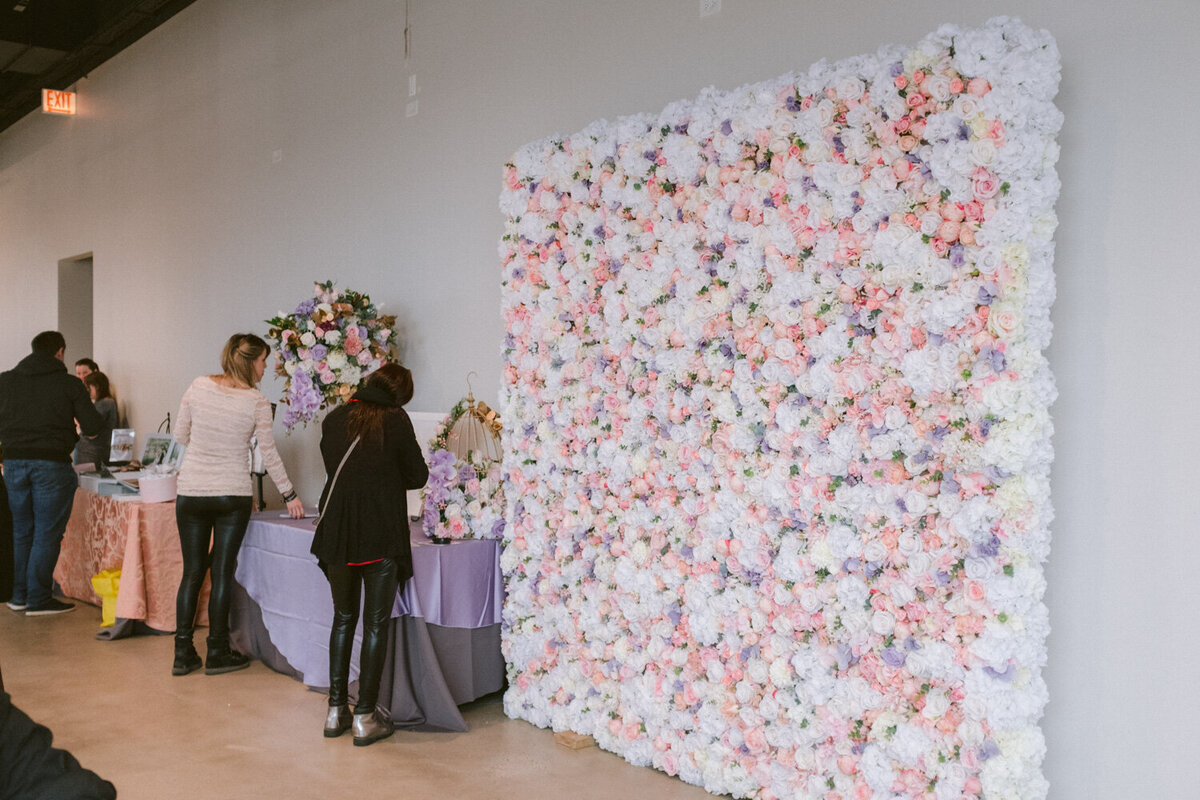 Elegant and colorful wedding backdrop with three people standing beside the table