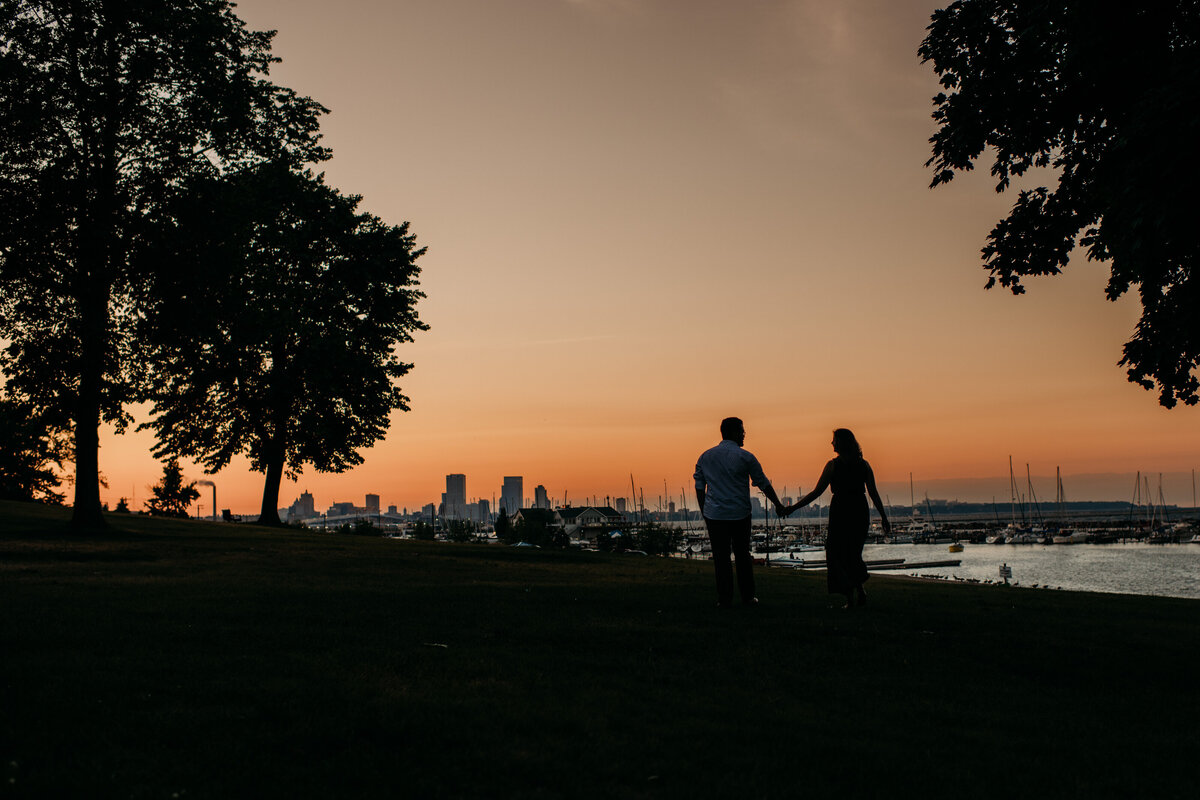 Silhouette of  man and woman holding hands at sunset