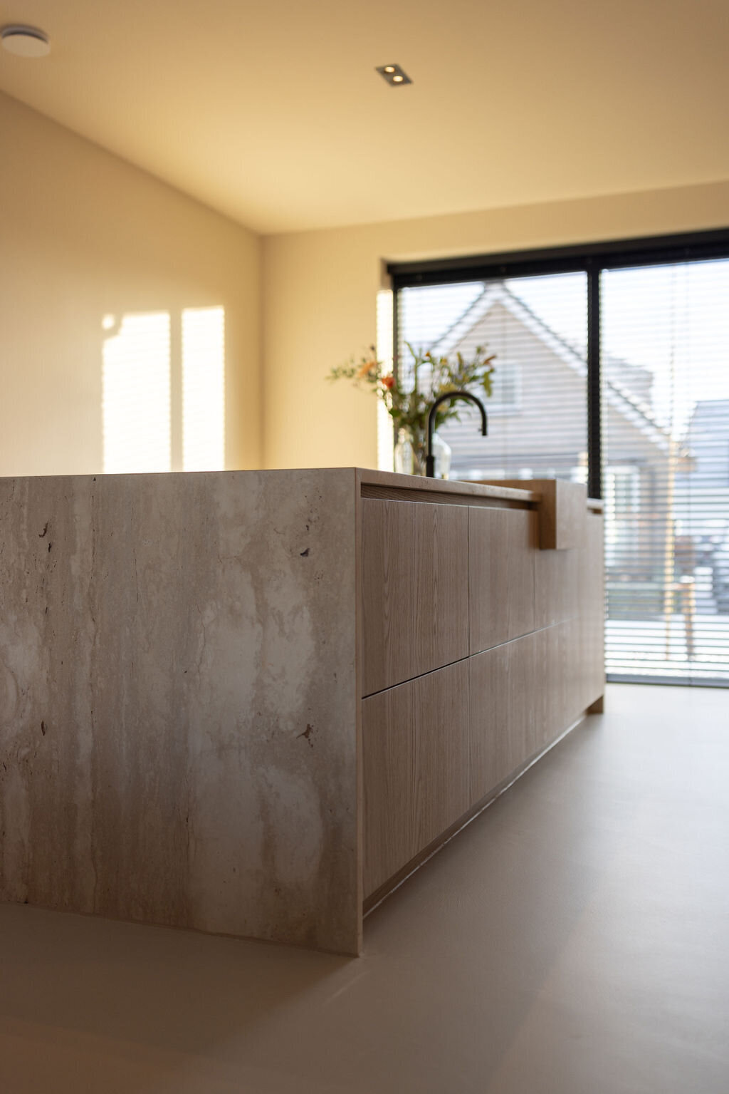 Moderne open keuken met een ruim kookeiland en houten elementen.