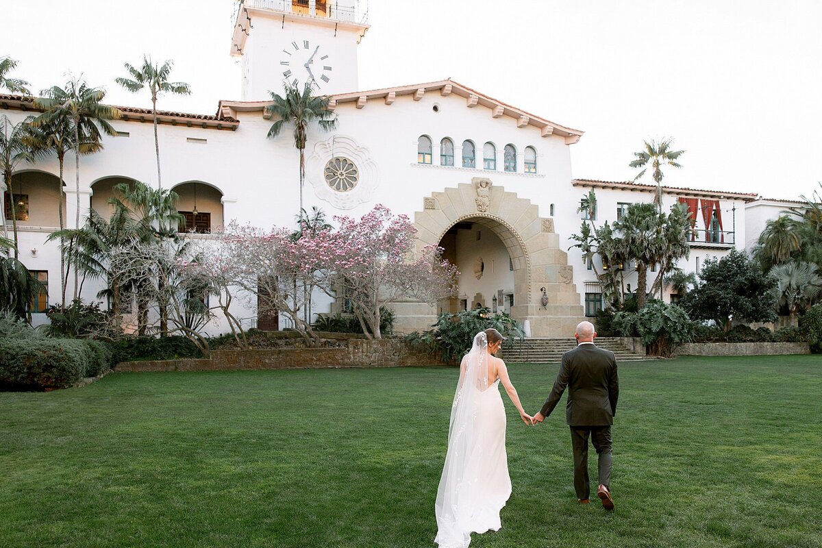 Bride and groom embrace on the peak of a mountain at Rocky Oaks Malibu