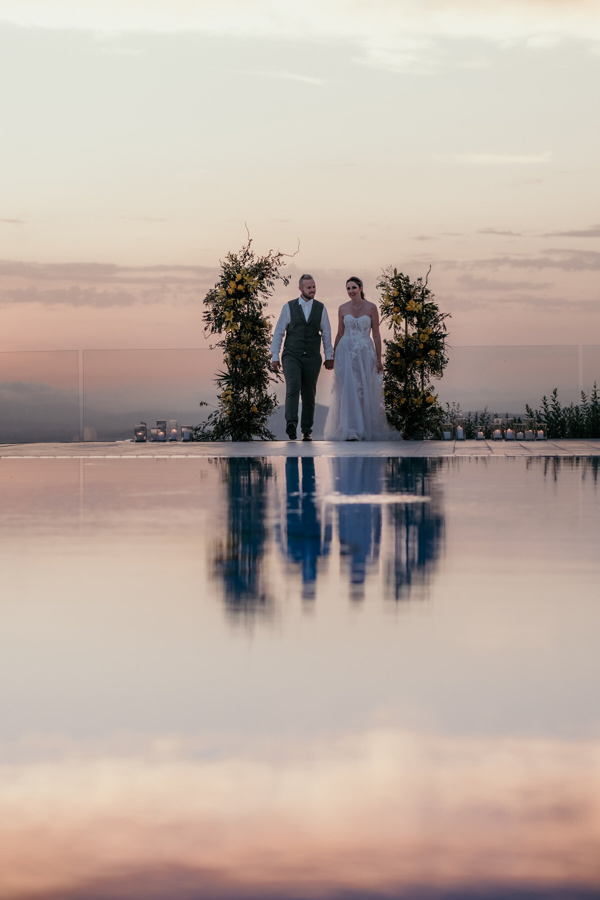 Die malerische Abenddämmerung spiegelt sich im Wasser des Pools, als das Paar darauf zugeht.