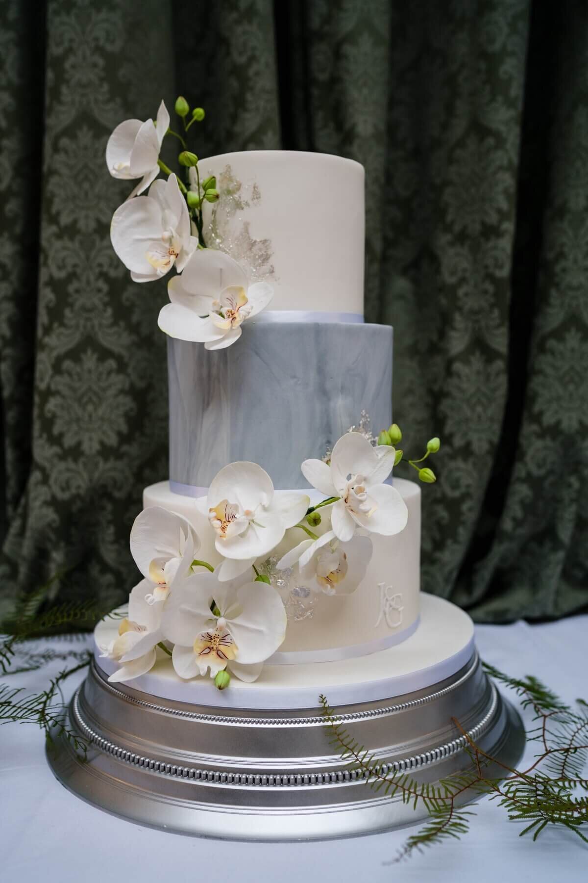 A three tier wedding  cake with orchid sugar flowers