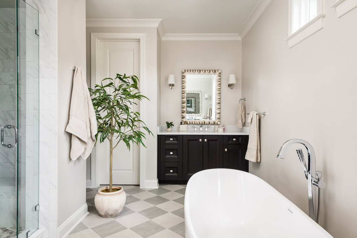 Elegant bathroom in Lake Norman, NC, with a black vanity, white walls, and natural decor.