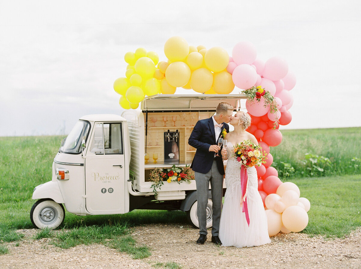 Bride and groom in front of  The Prosecco Cart, trendy and romantic mobile bar based in Calgary, AB. Featured on the Brontë Bride Vendor Guide.