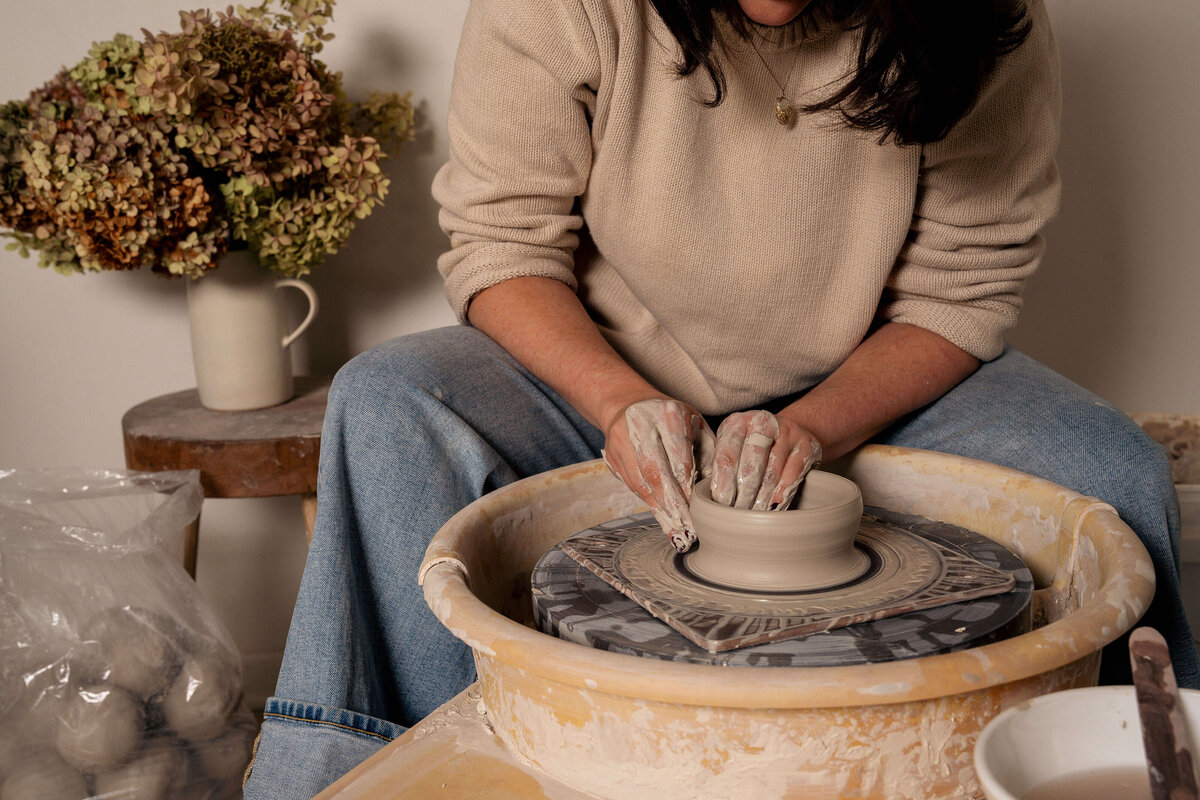 Lifestyle and Product photography in Greenville, SC featuring a woman on the pottery wheel