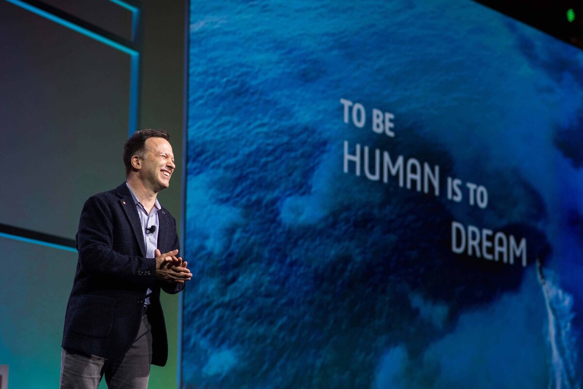 Gian Paolo Bassi CEO of Solidworks smiles from onstage with slide "To be human is to dream" behind him