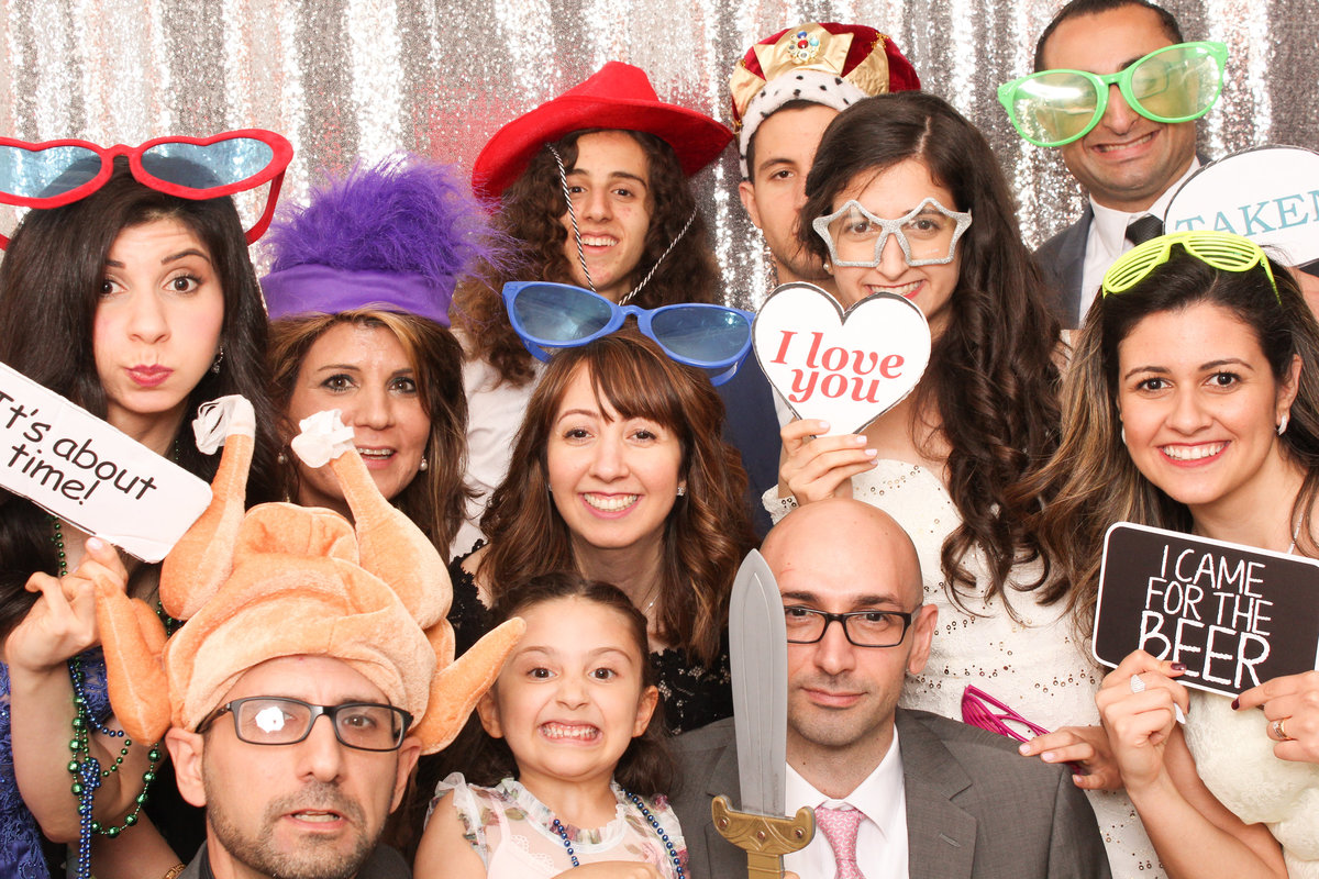 Group of friends squeeze in for a fun photo booth photo opportunity