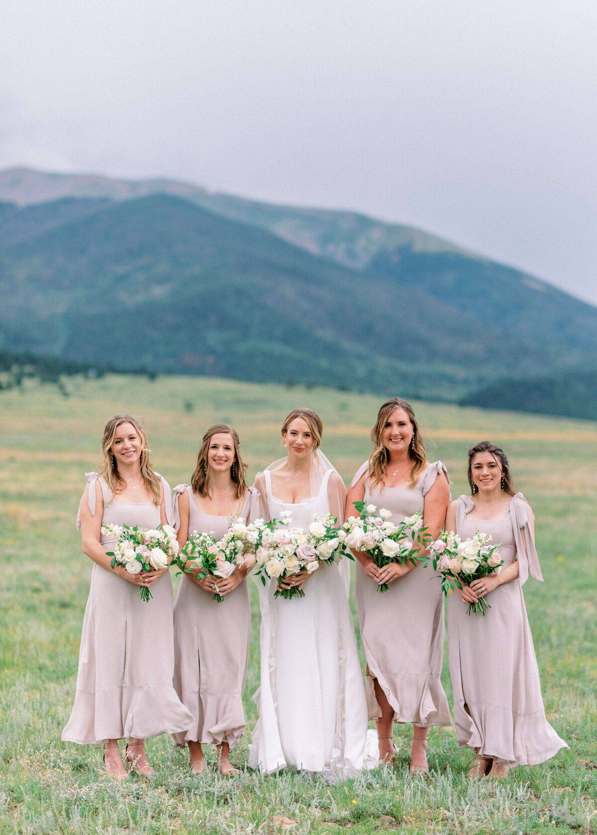 Wearing light mauve dresses, the bridesmaids complemented their pastel bouquets perfectly