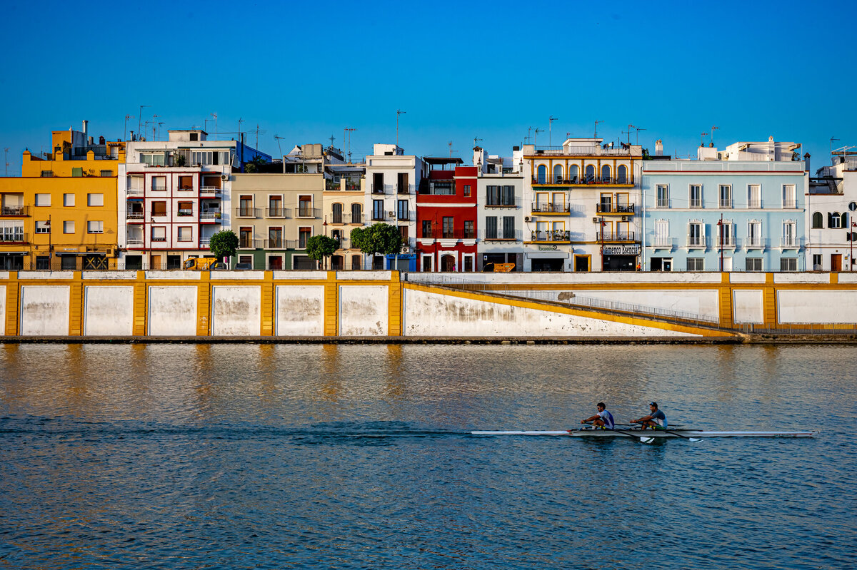 Sunrise on the River Guadalquivir in Seville, Spain as two skullers get an early morning row in.