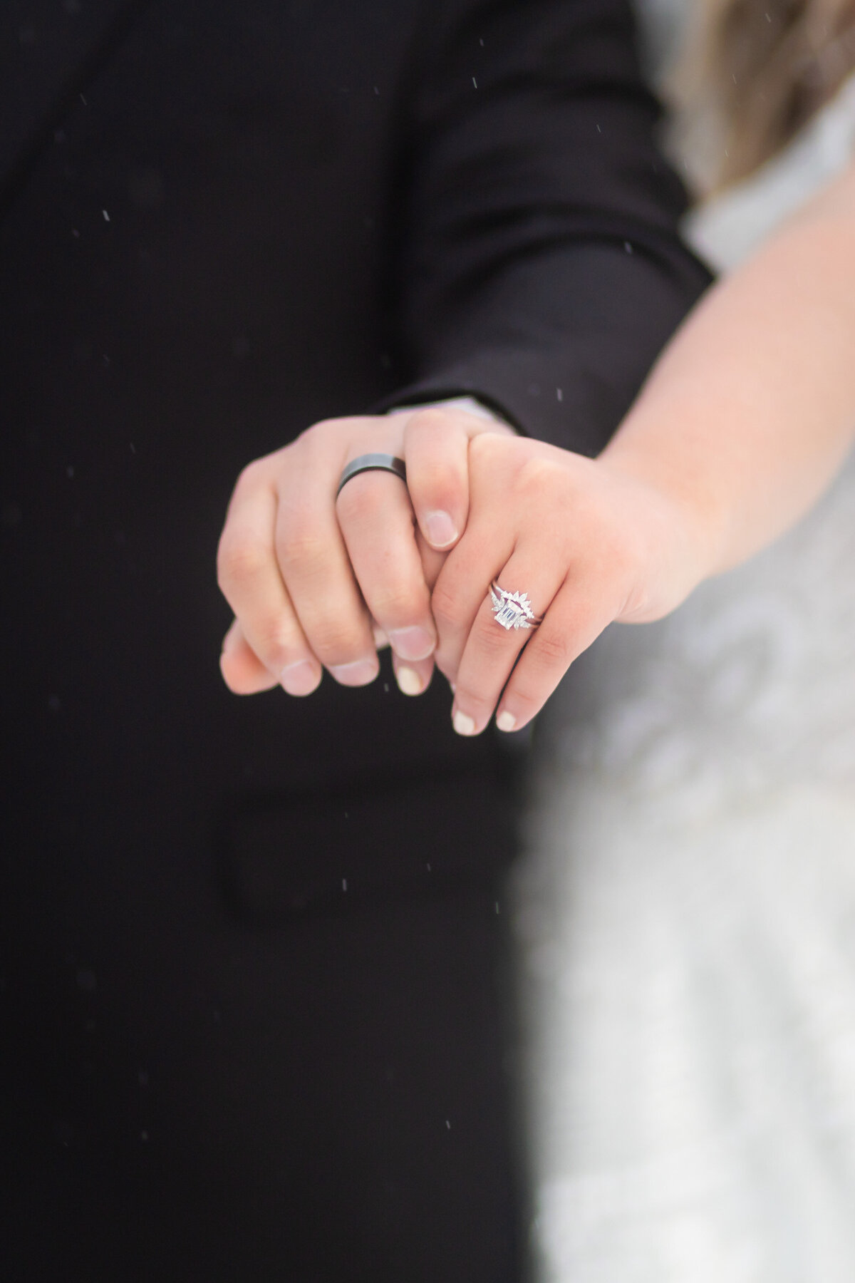 Groom and Bride showing their rings while holding hands