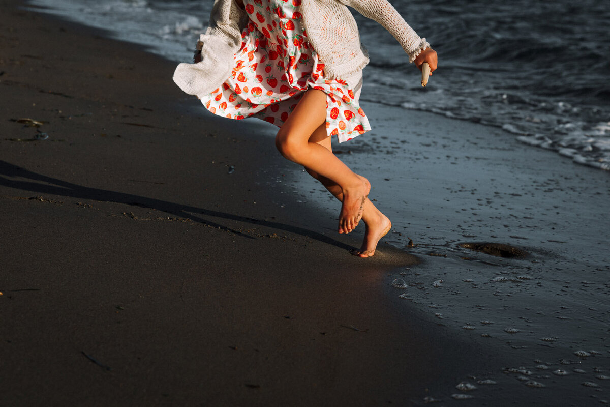 girl's legs running away from water at Alameda beach