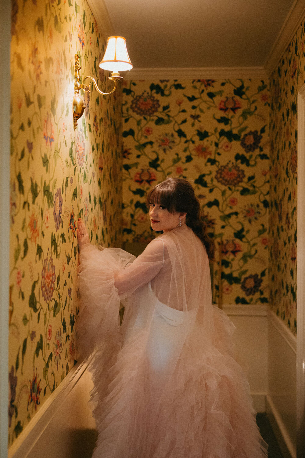 Bride in light pink standing on the hallway