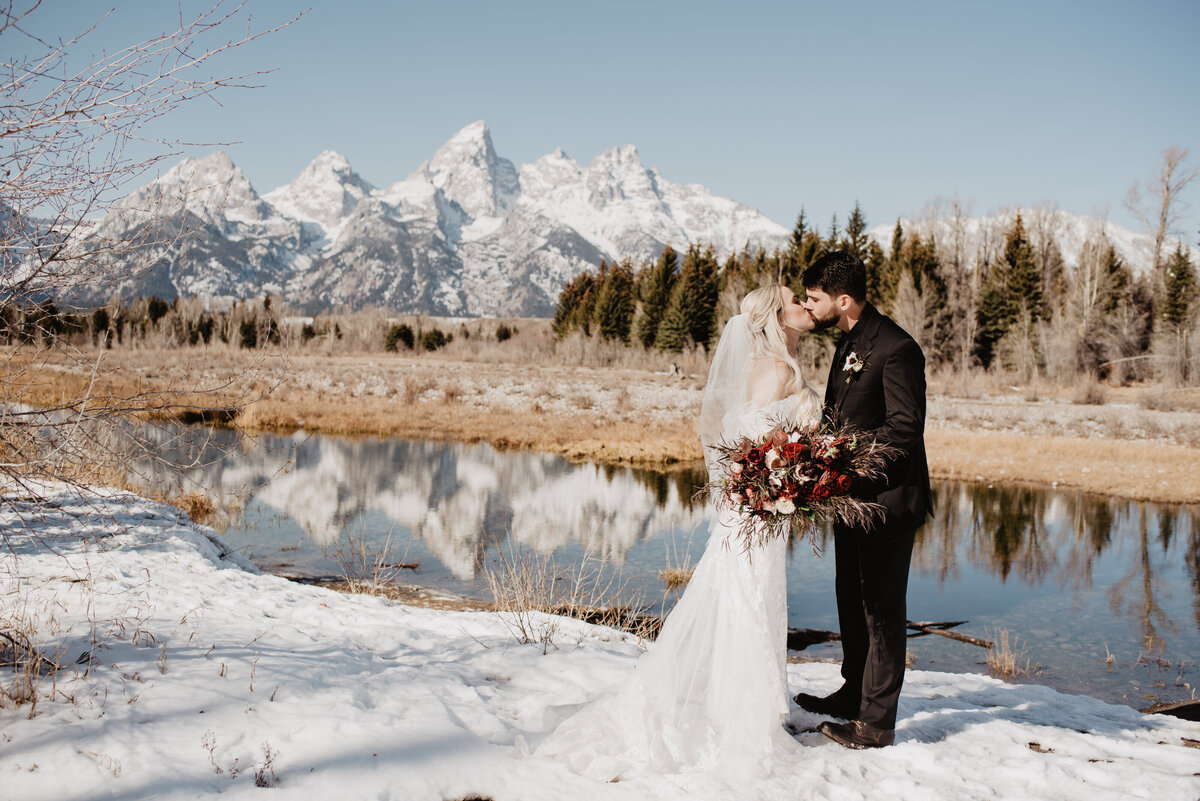 Jackson Hole Photographers capture bride and groom kissing in front of Tetons