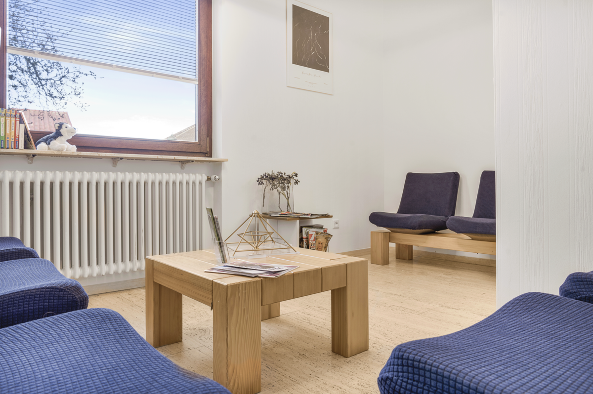 Komfortables Wartezimmer mit bequemen Sitzgelegenheiten und freundlicher Atmosphäre.