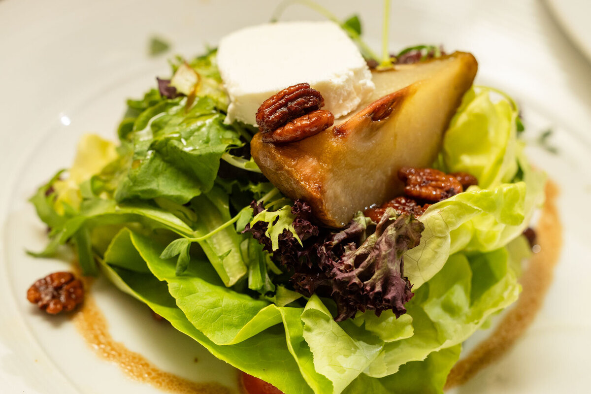 A close up of a salad with a pecan on top