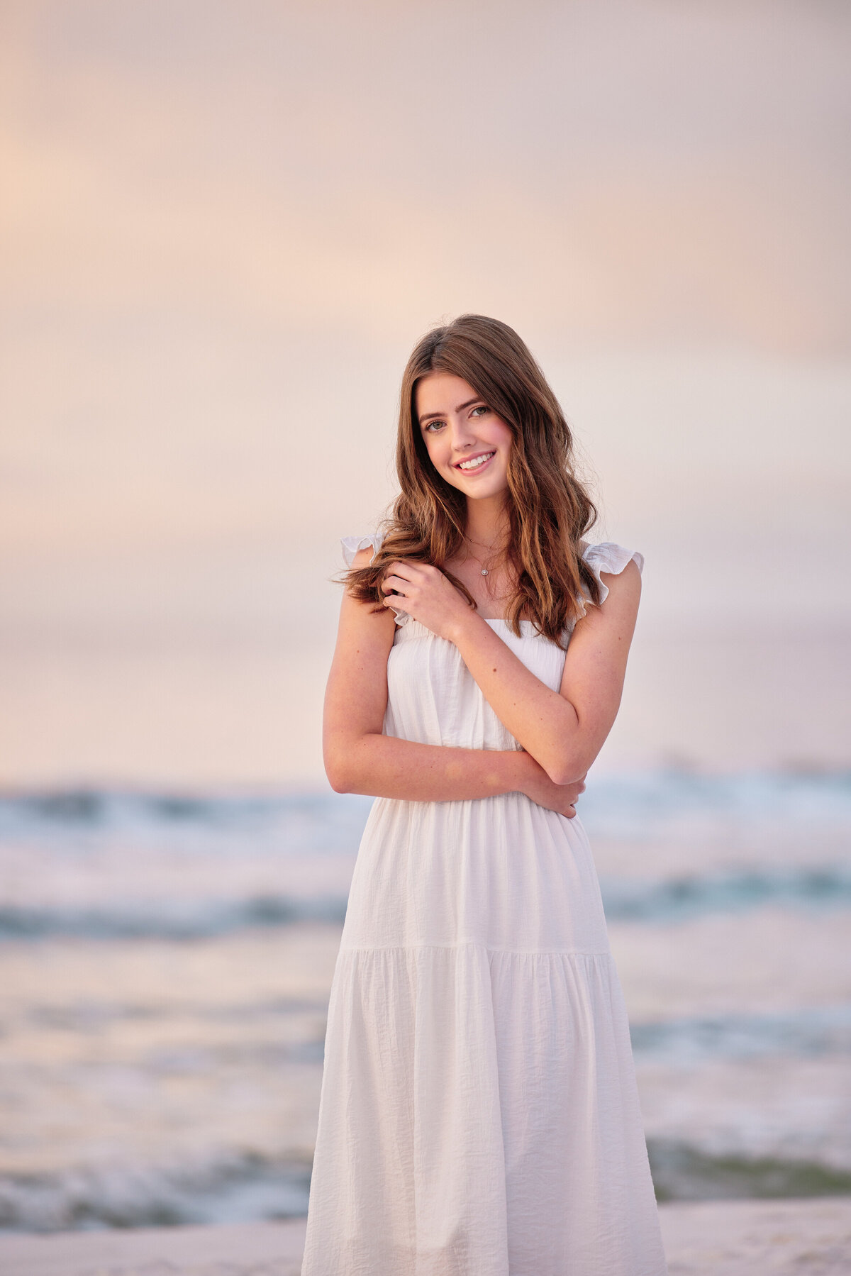 A girl smiling with her arms across her body