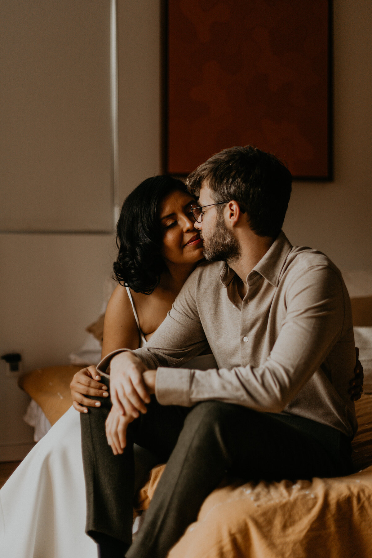 bride and groom sitting on  a bed together before their ceremony