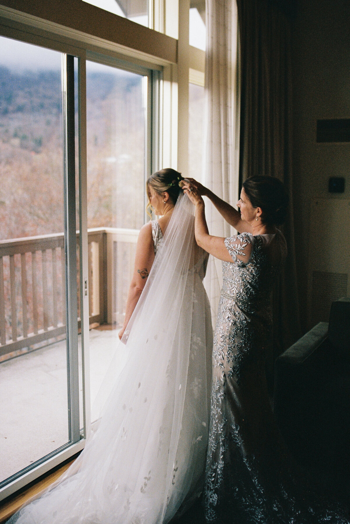 mom putting veil on bride
