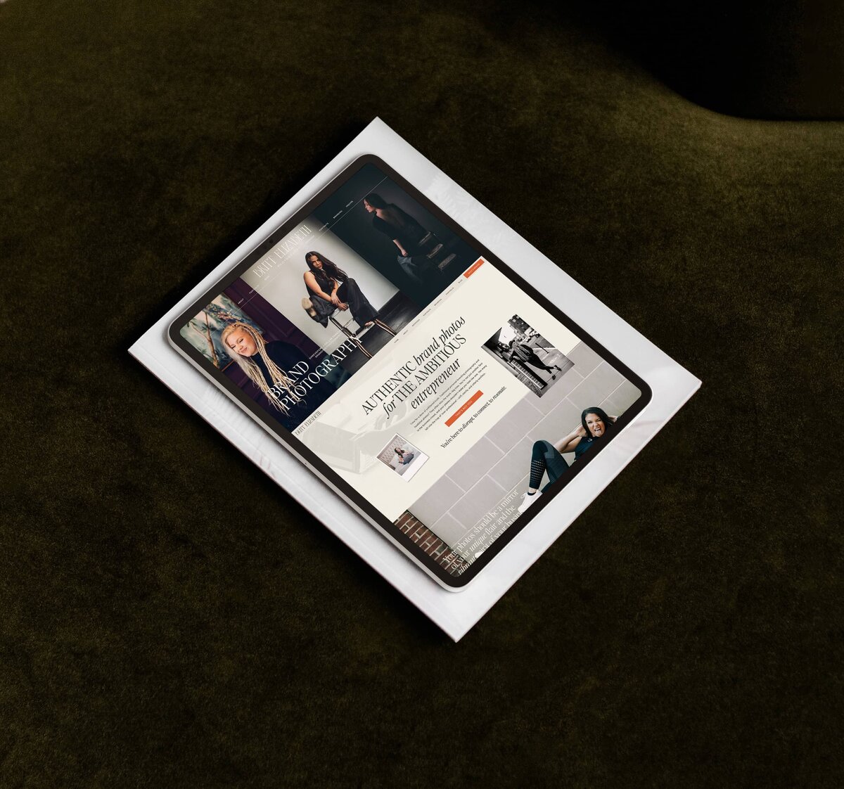 A photographer's website on an iPad lays  on a dark green surface, displaying pages with images of people and text related to photography and personal branding for photographers.