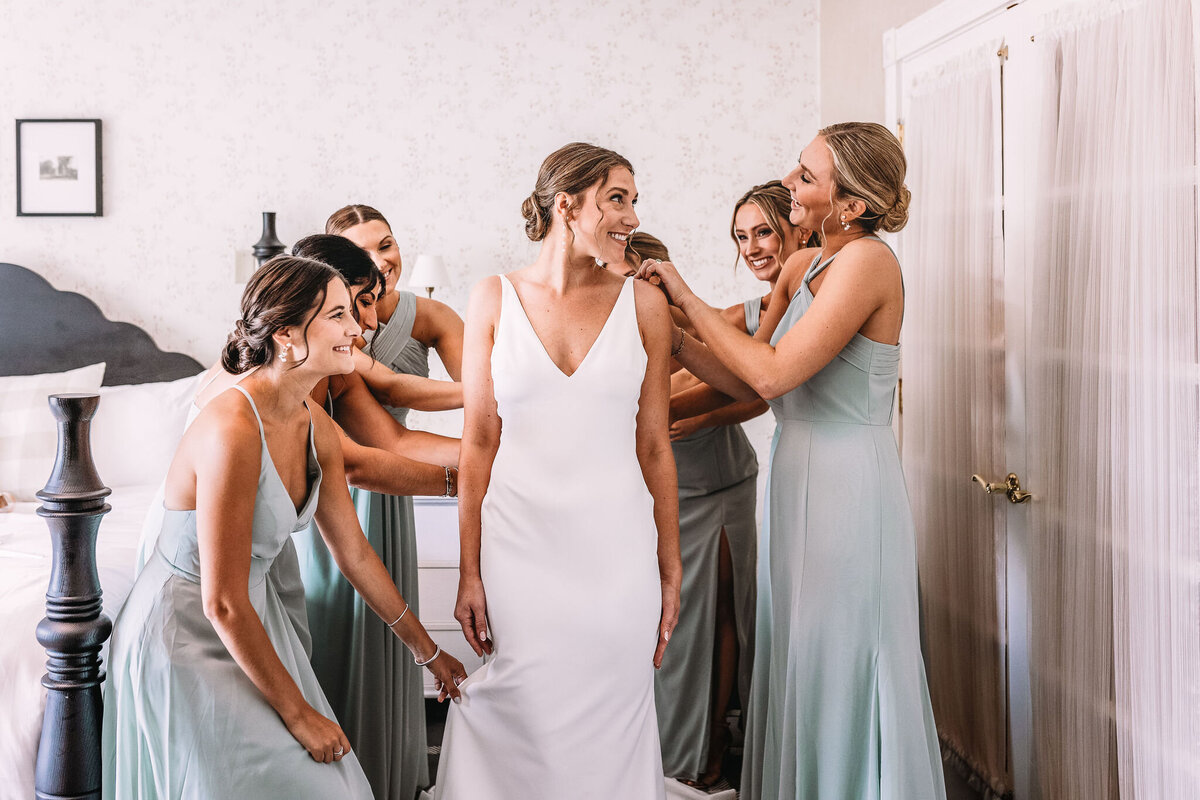 bridal party fluffing and attending the bride in the getting ready room at Wentworth Inn in Jackson NH by Lisa Smith Photography
