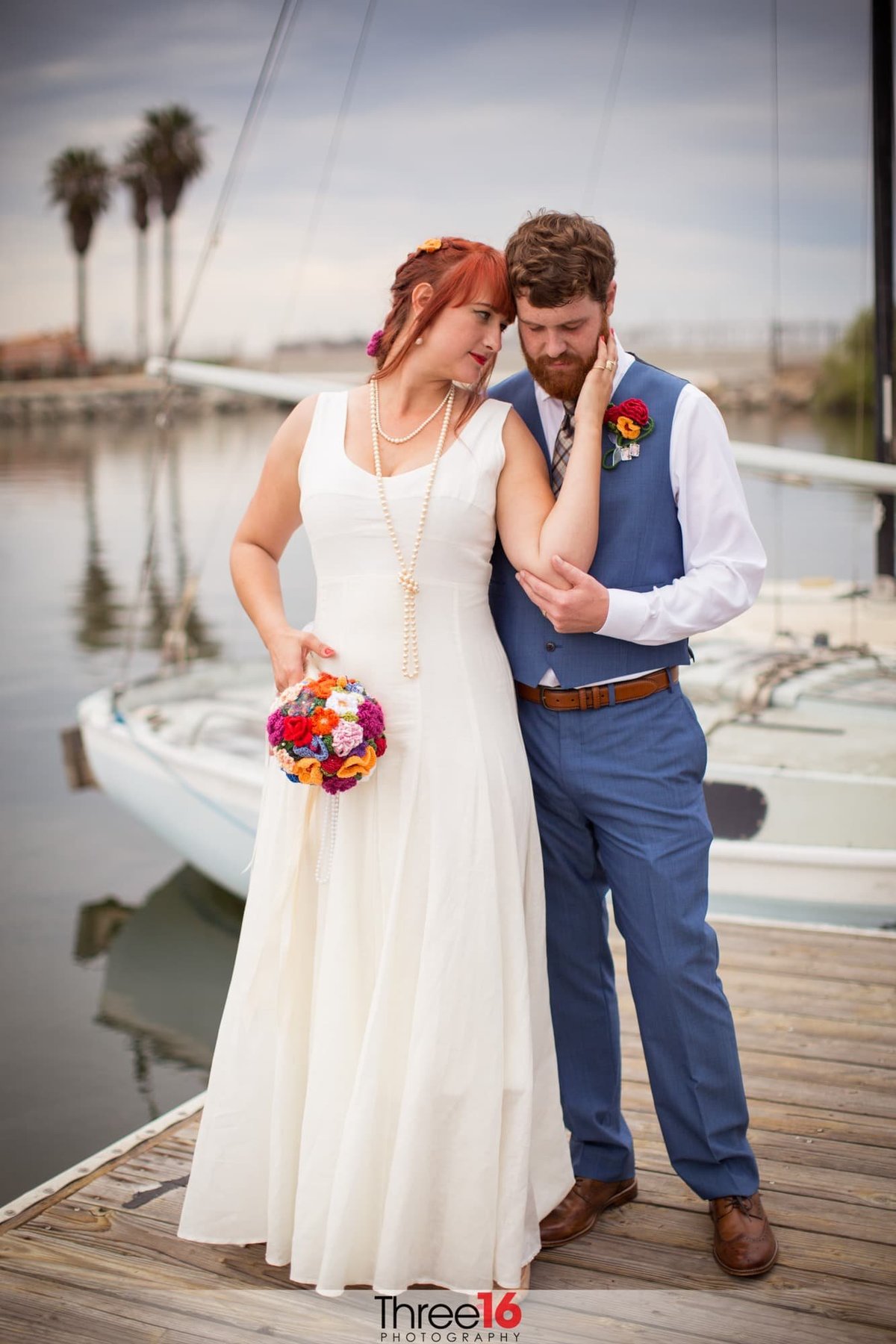 Sweet tender moment between newly married couple standing on the dock