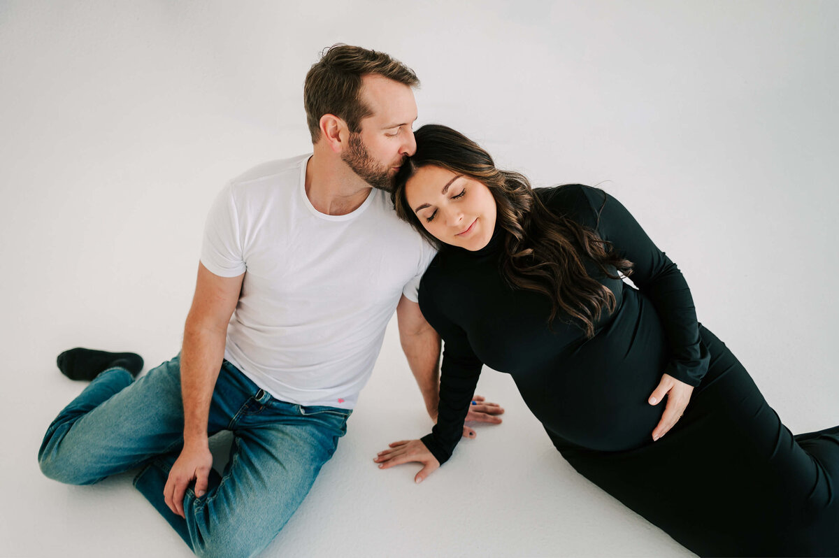 Joplin Mo maternity photographer Jessica Kenendy of The XO Photography captures pregnant mom leaning on husbands shoulder