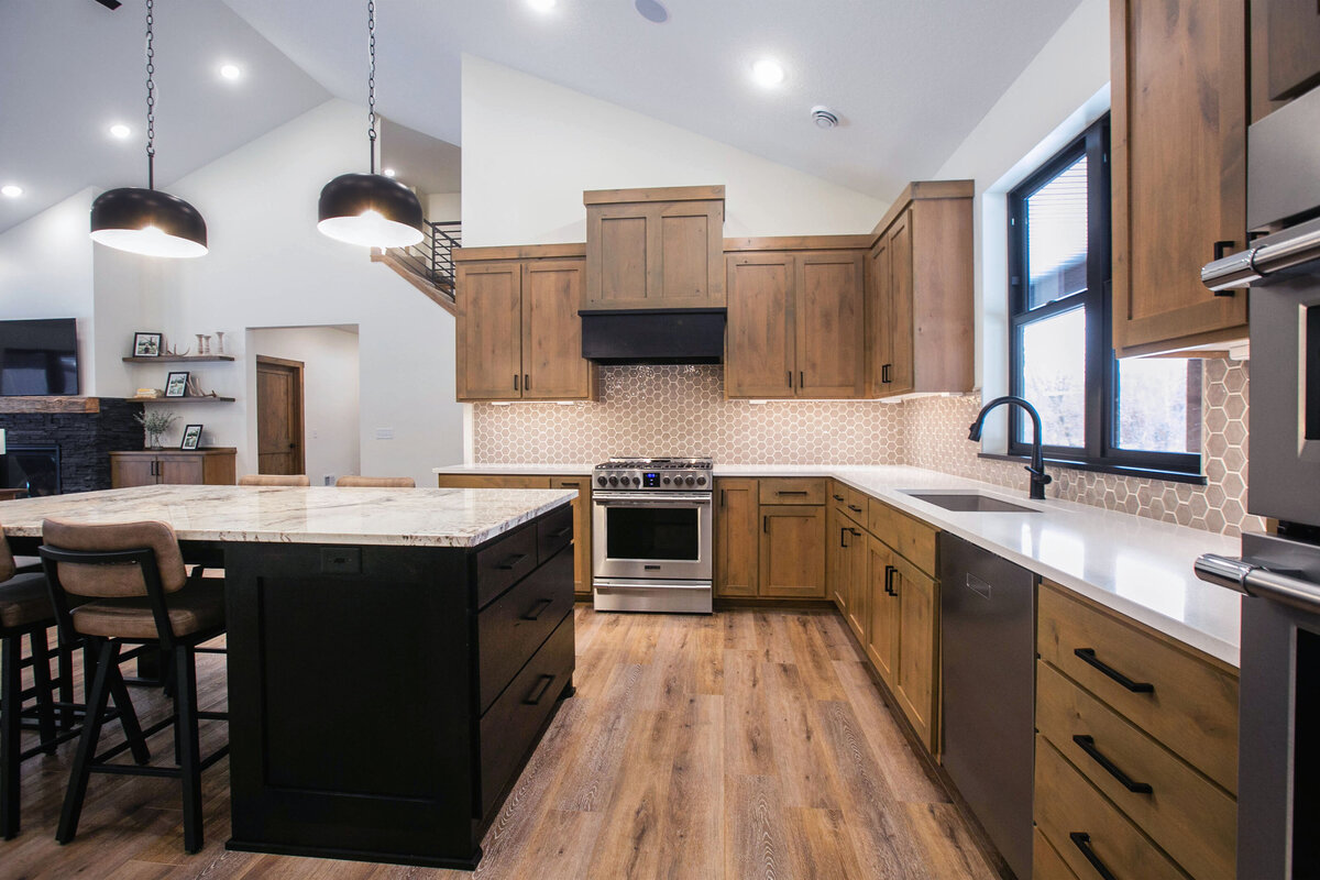 Open kitchen with dark cabinets, large island, and quartz countertops in an Elk River custom home