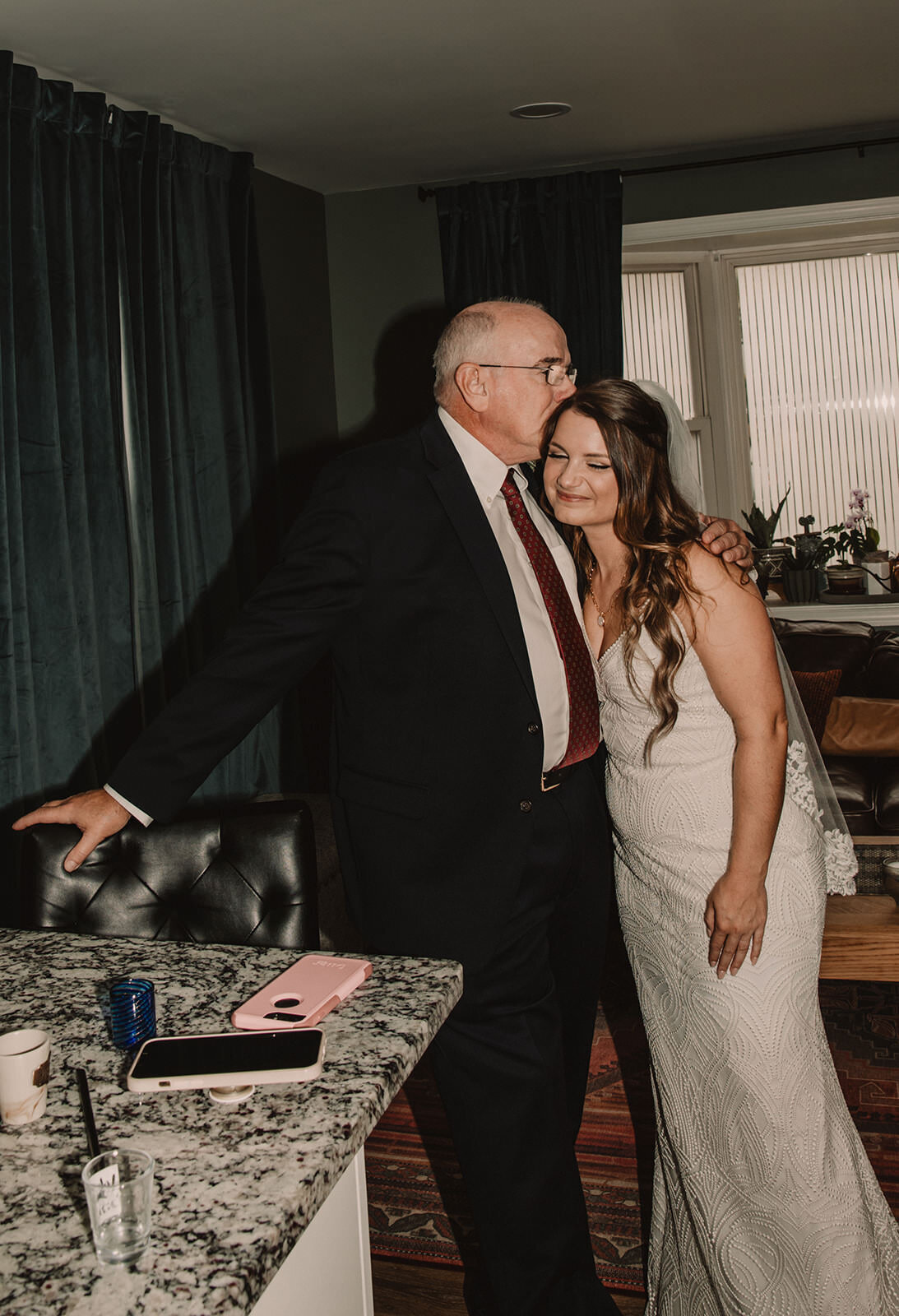 A parent kissing their child's head on their wedding day 