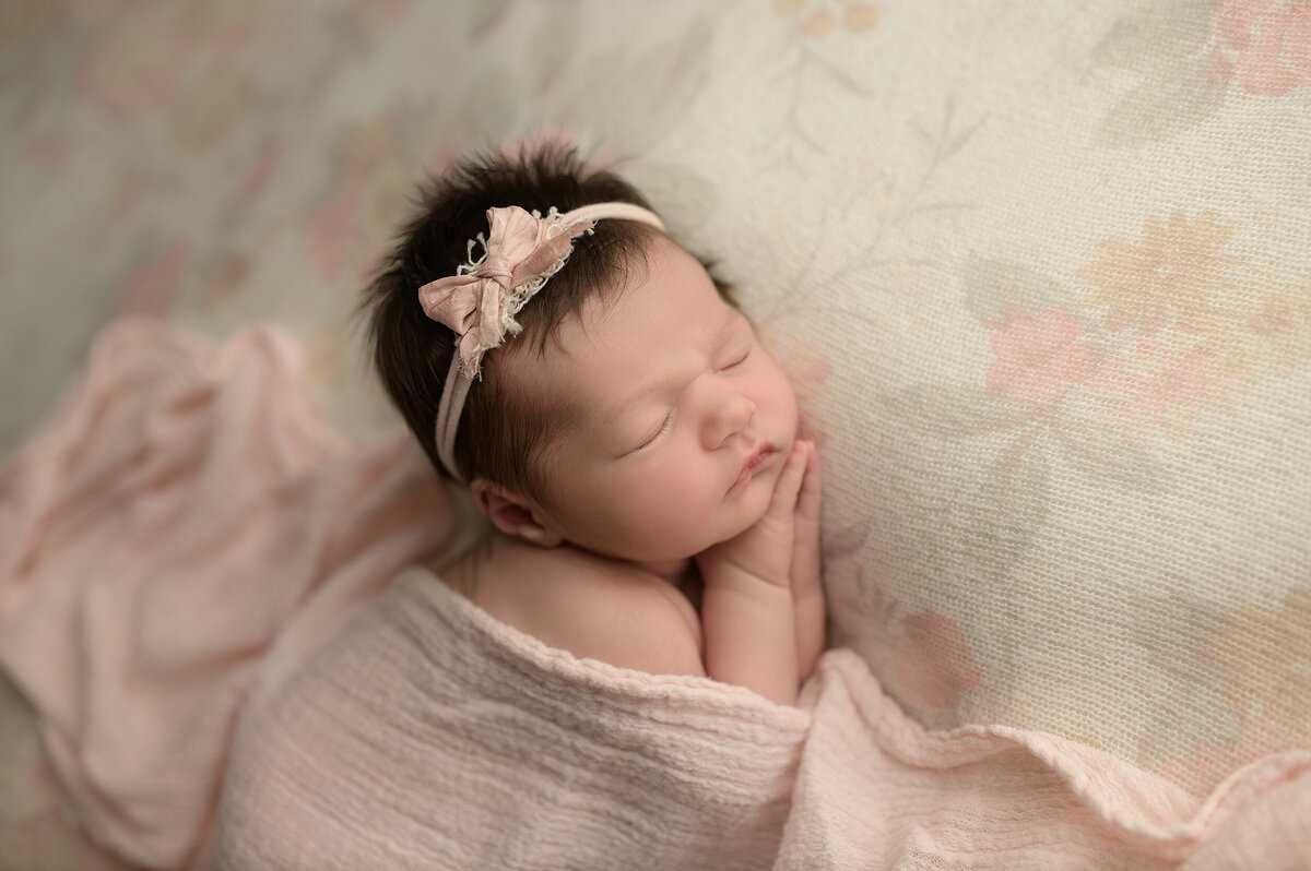 sleeping newborn baby in pink blanket