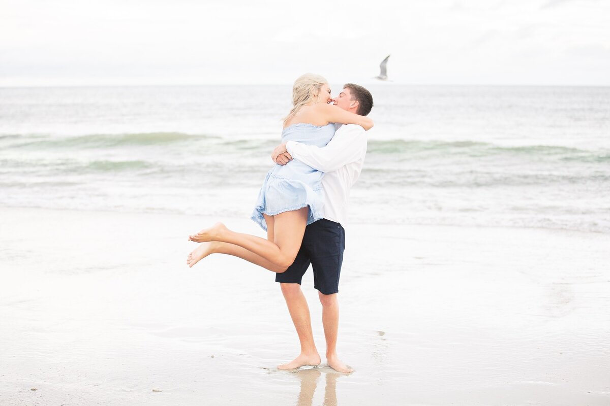 Boyfriend swings girl around at the beach