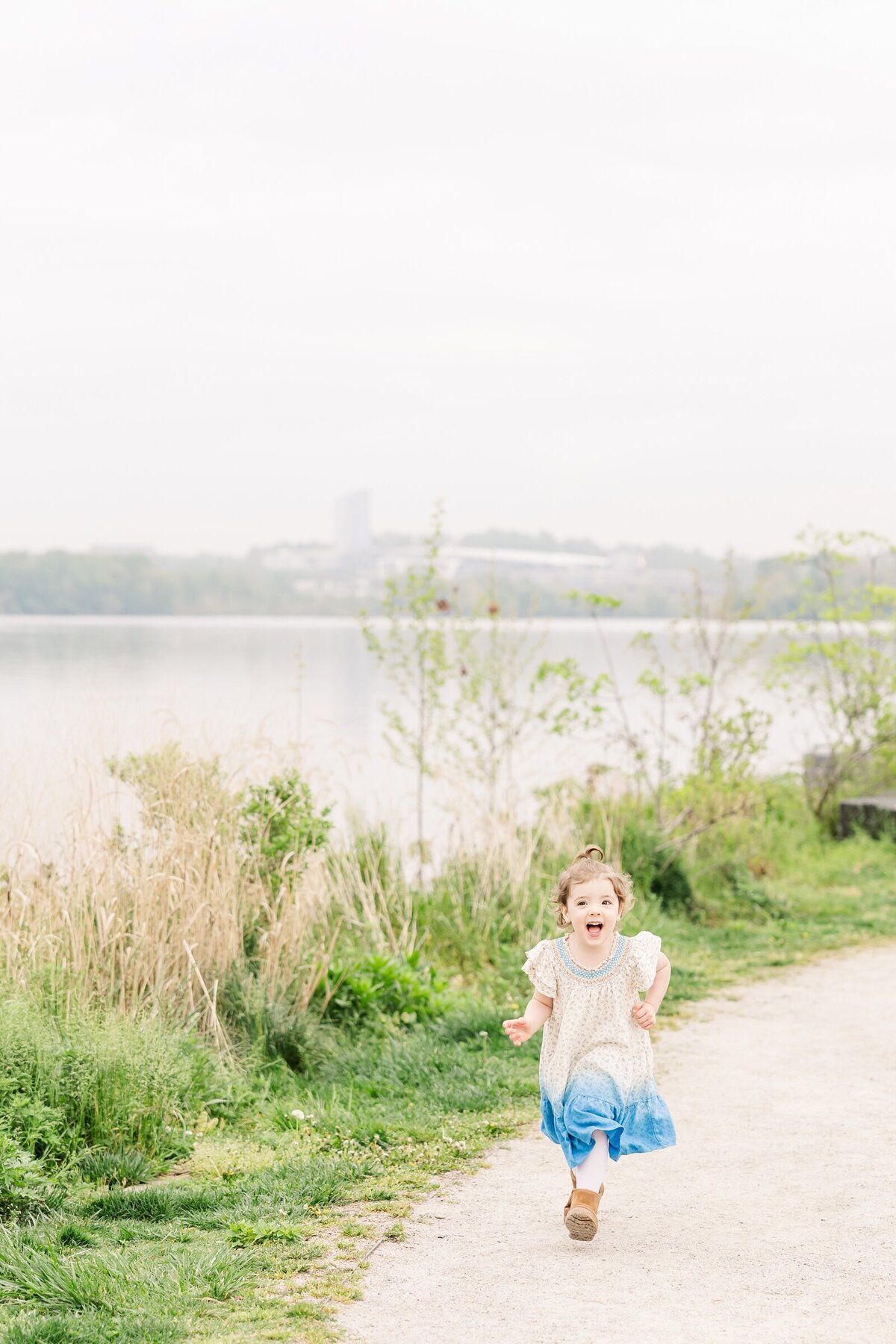 Little girl running near a river