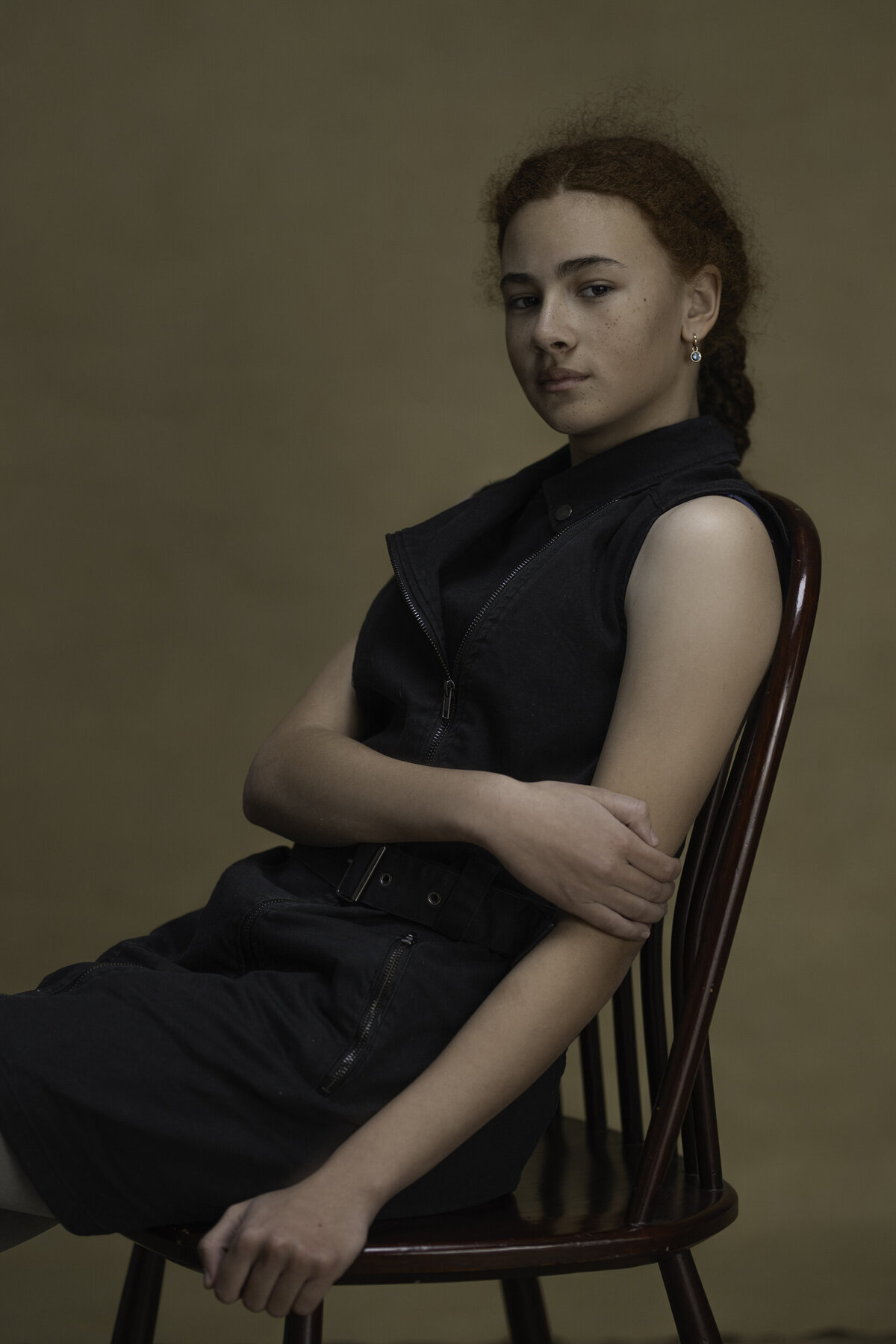 Studio Ace Photography Zaltbommel tijdloos portret van dame met ginger kroes haar gevlochten hangend op een stoel