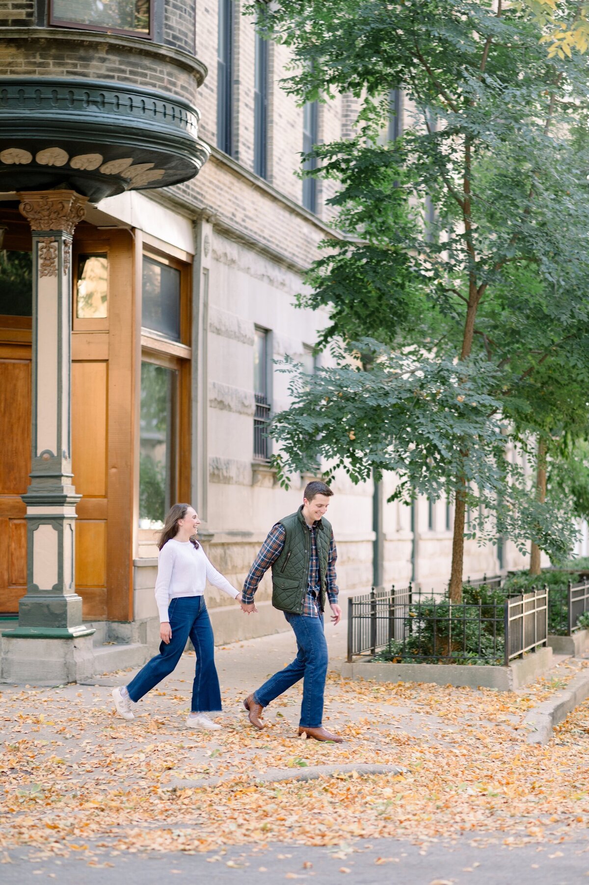 engaged couple walking in Downtown Chicago while holding hands