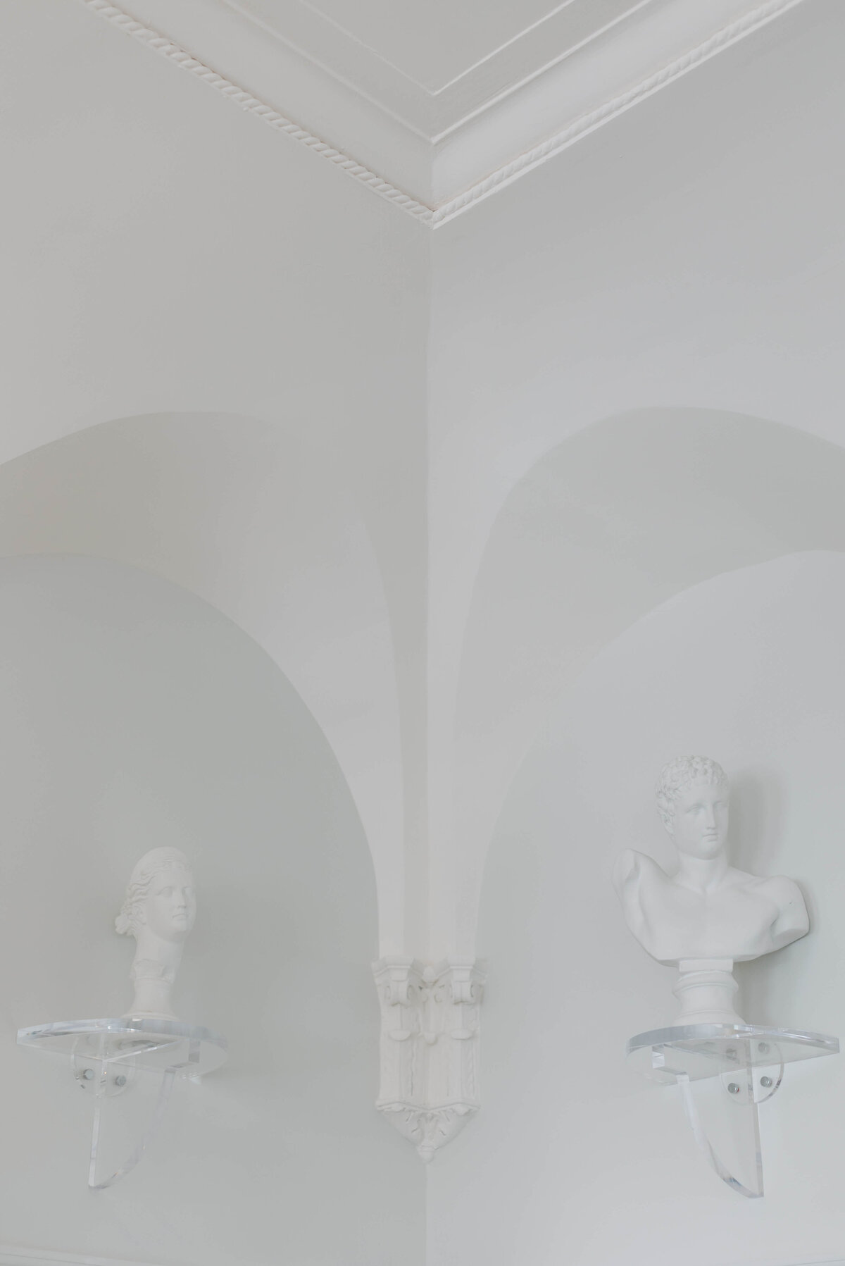 Sculptures sit in the corner of a room.