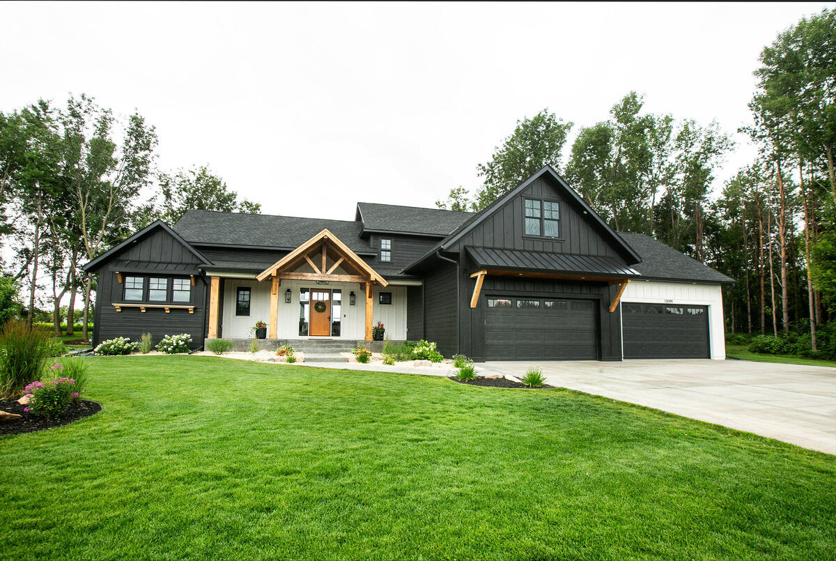 Exterior view of custom home in Otsego, Minnesota with modern wood details and front porch built by Cornerstone Custom Builds