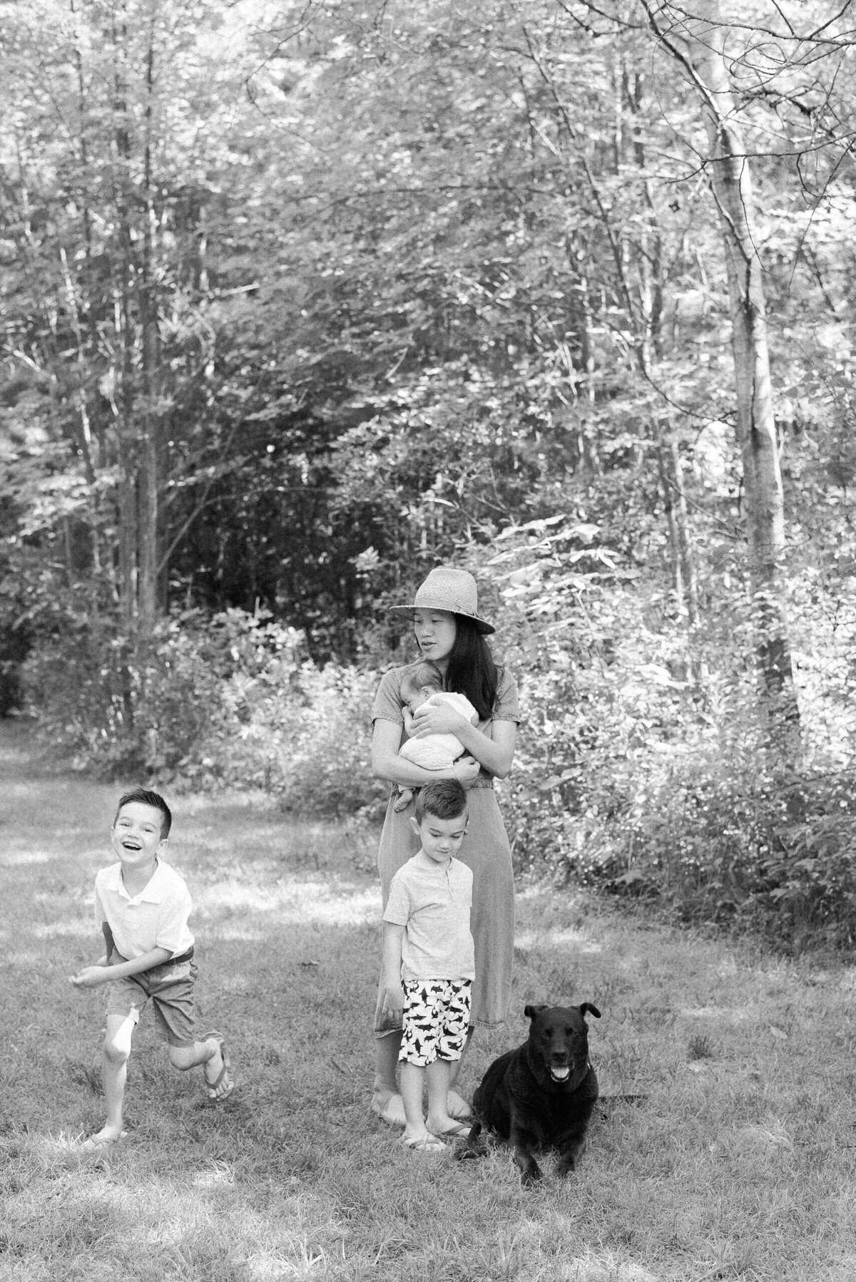 Kim-Trang holds her newborn son while her children run around them