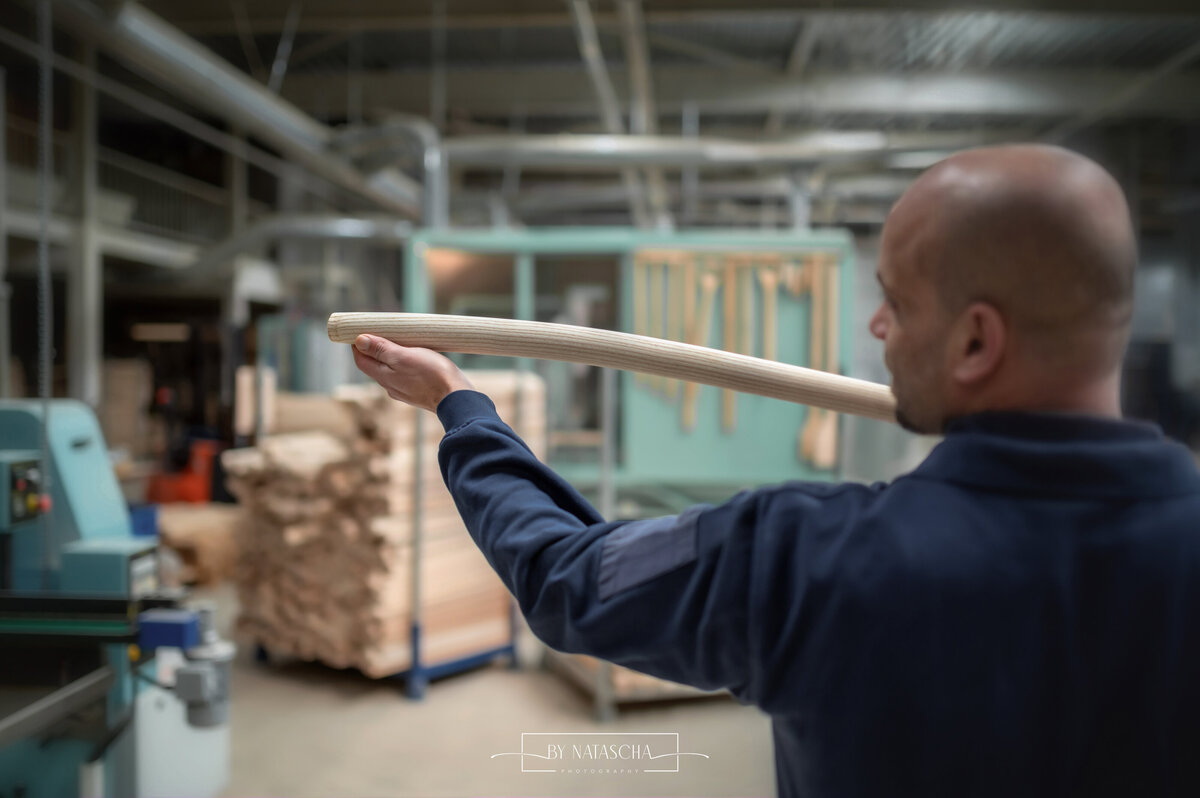 Man met houten steel in de hand ter controle van het productieproces