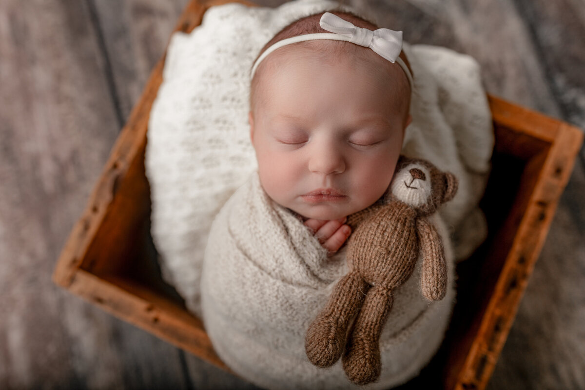 Newborn-holding-teddy bear-wood crate