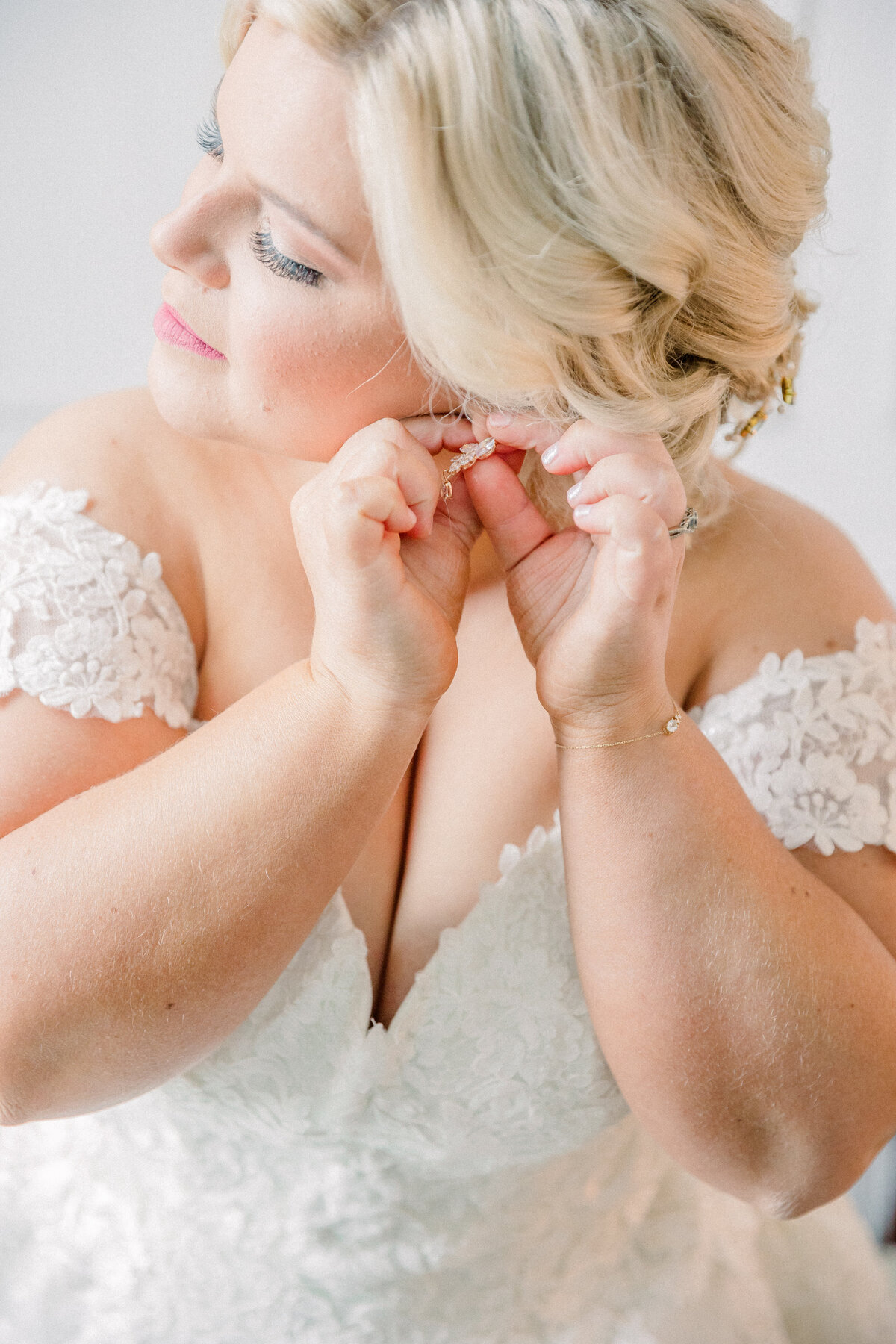 Bride putting on her earrings during getting ready