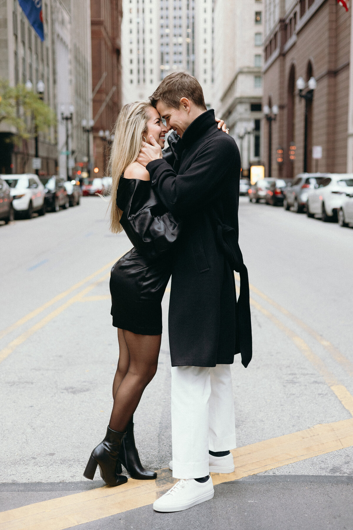 Fiances holding each other in front of Chicago Board of Trade during engagement shoot in Chicago, Illinois.