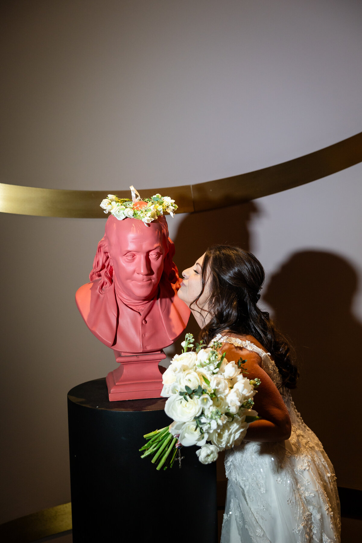 bride makes kissy face at benjamin franklin bust statue wedding photography by good omen photo co