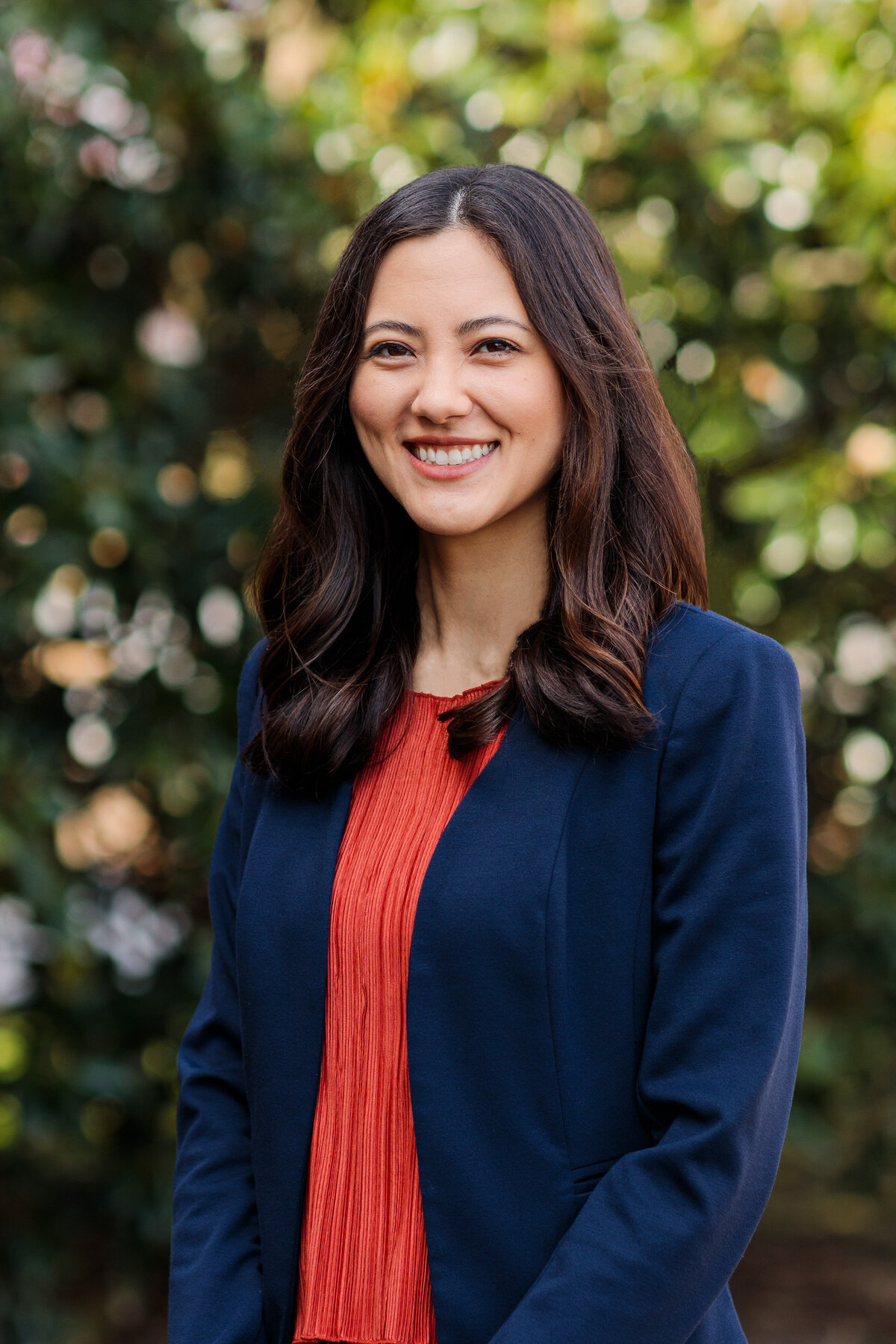 Woman smiling with red shirt and blue jacket for professional headshot