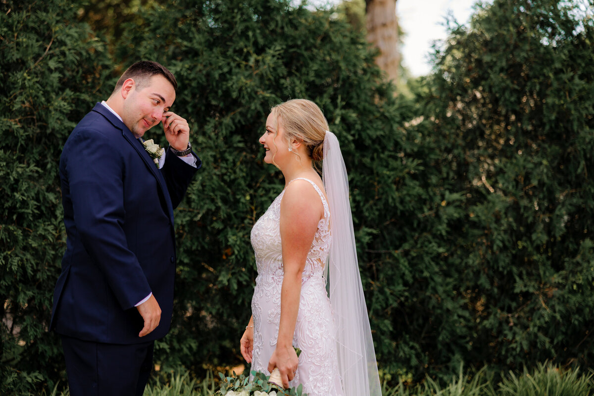 Groom sheds a tear as he compliments his wife on her beauty.