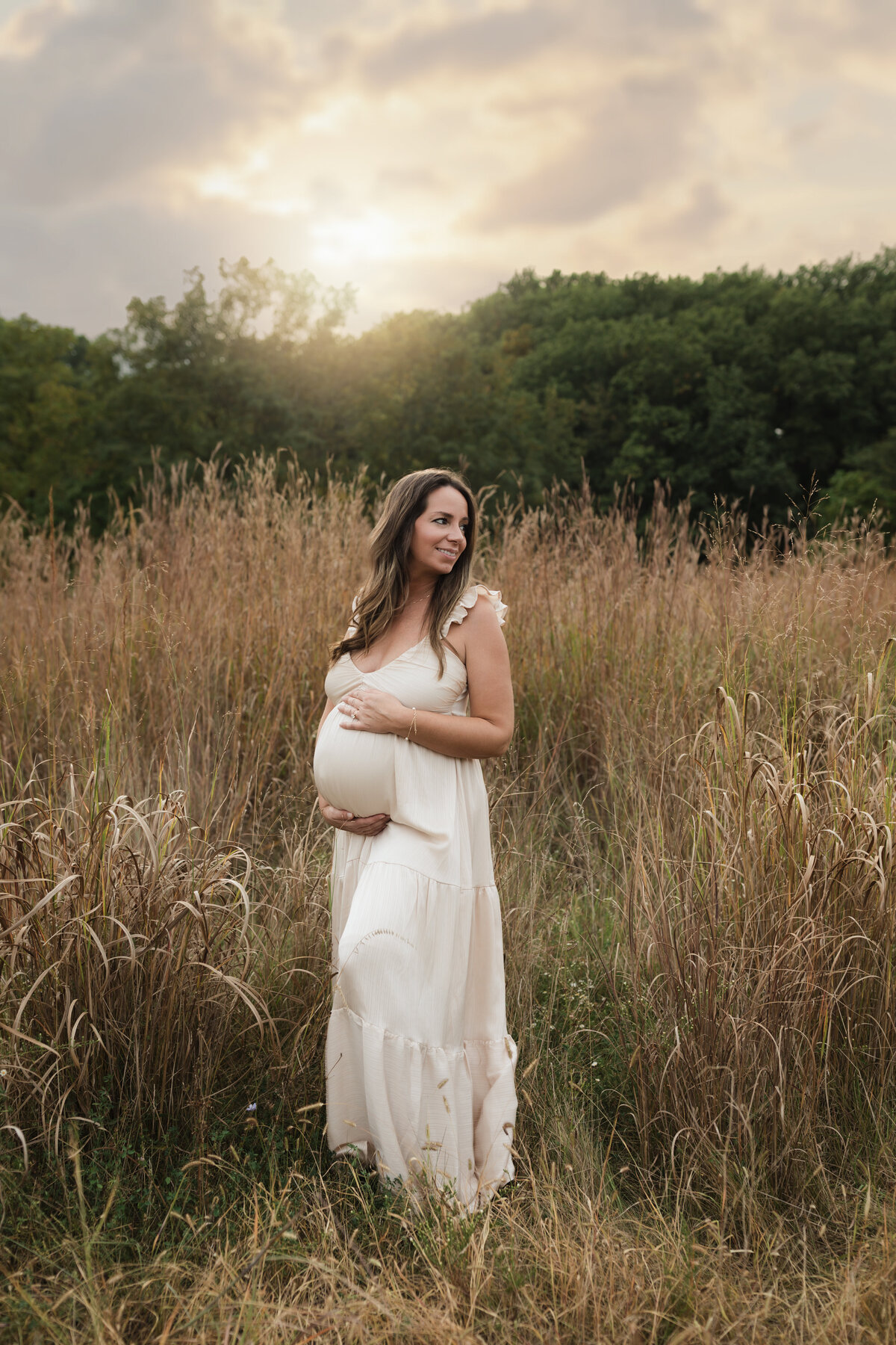 pregnant mother in pink silk maternity gown holding baby bump for maternity photoshoot cleveland maternity photographer
