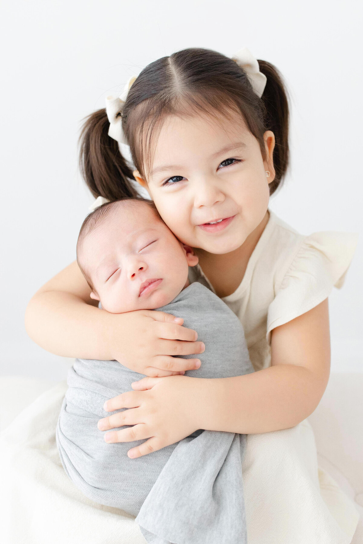 Big sister holding little brother for Northern Virginia Newborn Photography session