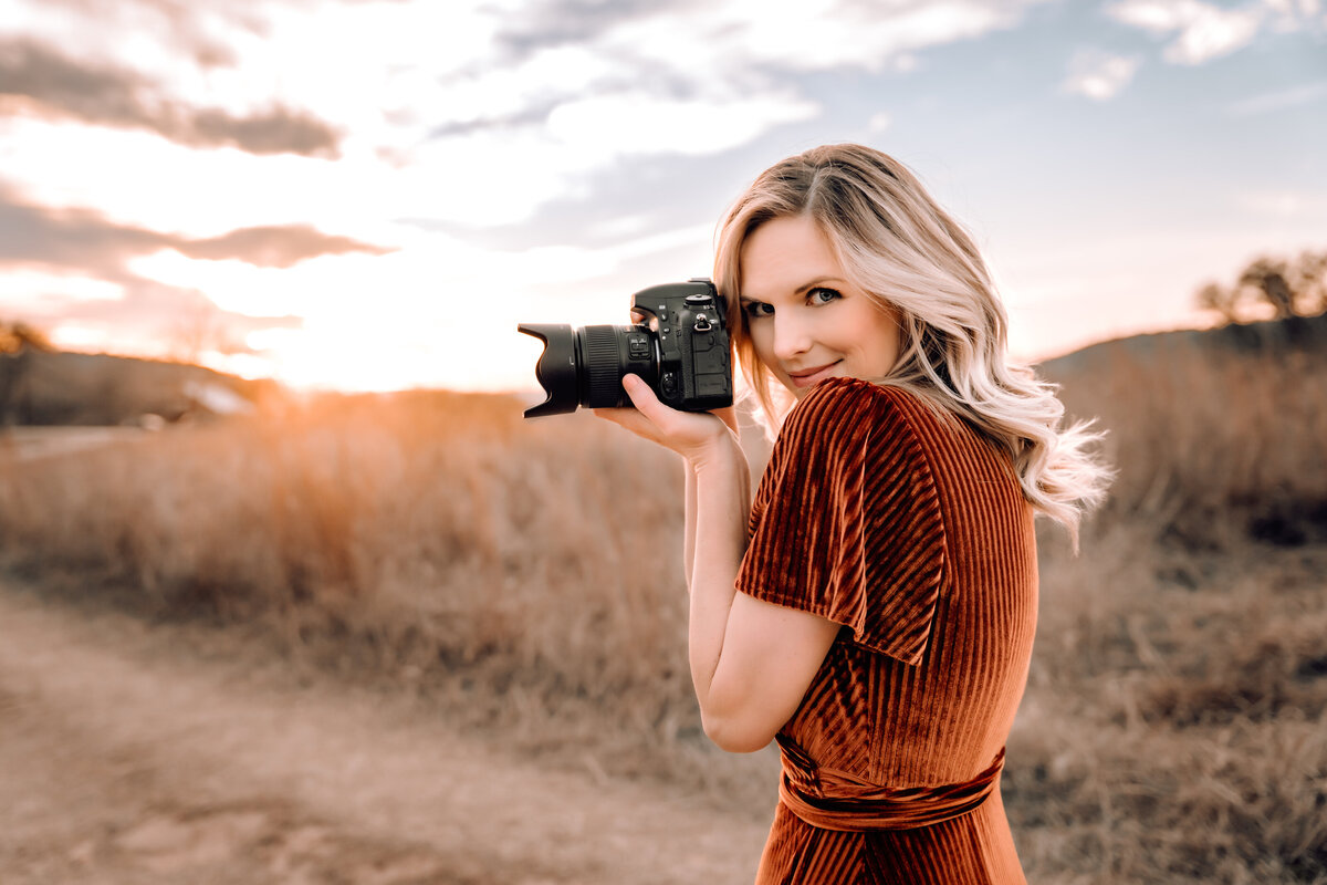 woman smiling holding camera in the desert