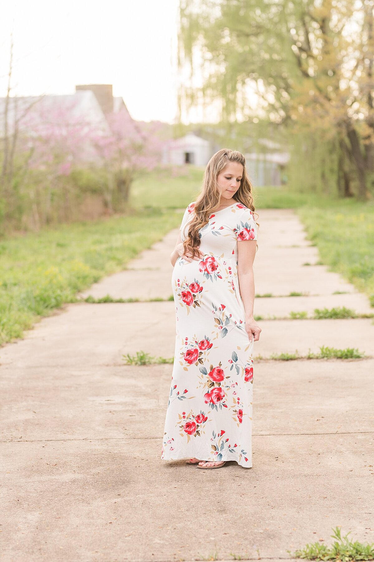 Mommy to be on sidewalk in a floral dress during her maternity session in hickory nc