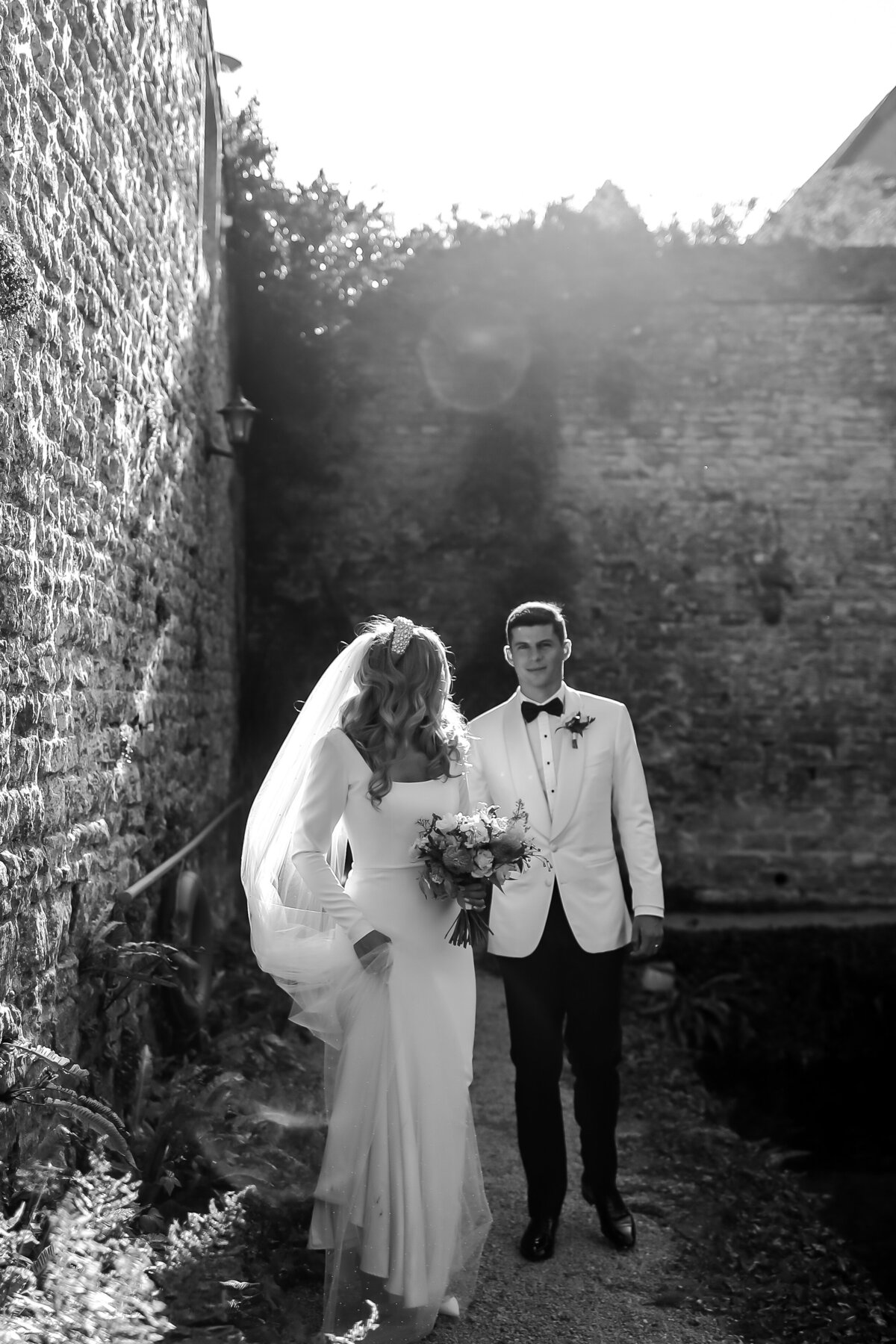bride-and-groom-walking-in-black-and-white-at-luxury-wedding-at-le-manoir-aux-quat'saisons