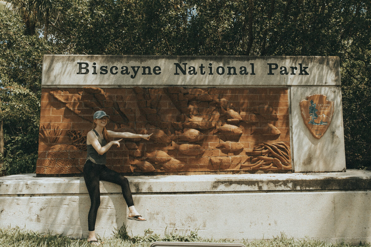 women sitting in front of biscayne national park sign